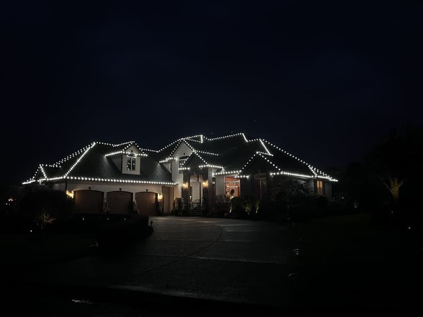 Decorated house with festive lights glowing at night, showcasing a holiday atmosphere.